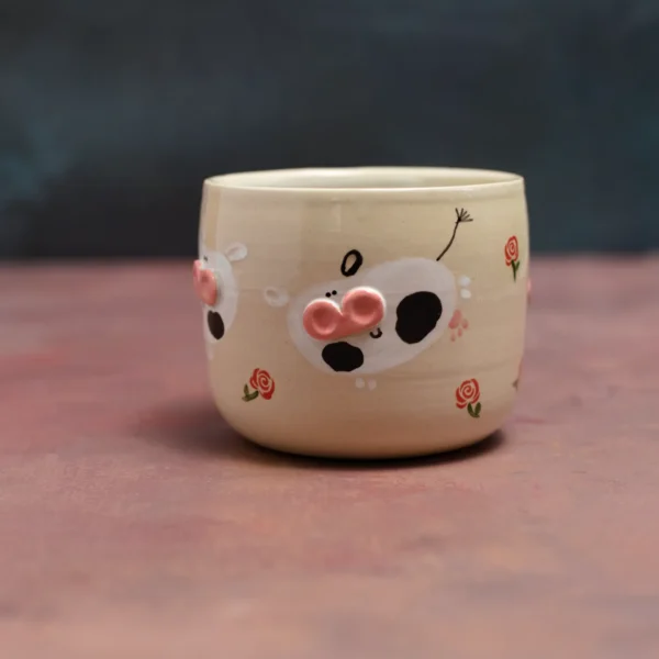 Kubek krówki wśród róż