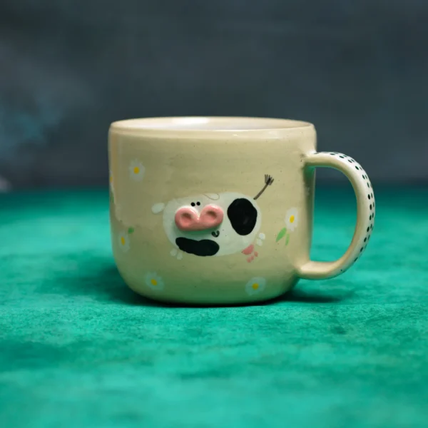 Kubek krówki wśród stokrotek