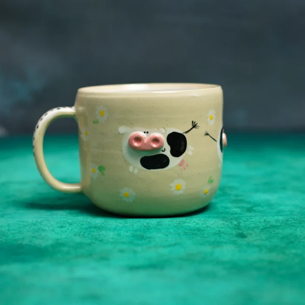 Kubek krówki wśród stokrotek