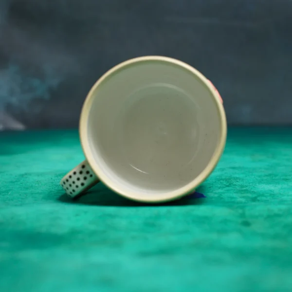 Kubek krówki wśród stokrotek